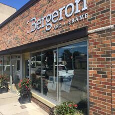 The outside view of Bergeron Art +Frames storefront: a brown brick building with glass windows.