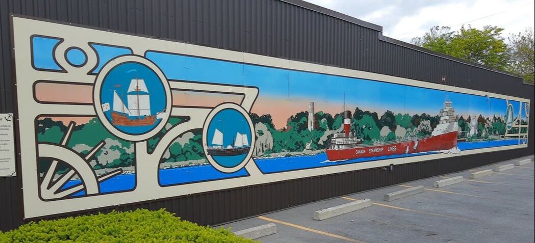 The mural Passage of Time can be seen on the east side of our building as you drive west.  